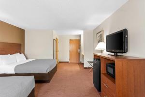 ein Hotelzimmer mit einem Bett und einem Flachbildfernseher in der Unterkunft Quality Inn in Sawyer