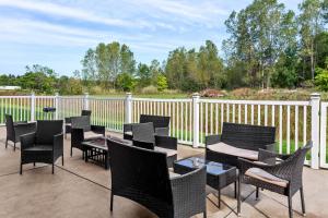 eine Terrasse mit Stühlen, Tischen und einem Zaun in der Unterkunft Quality Inn in Sawyer
