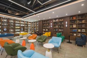 a library with colorful chairs and tables and shelves at James Joyce Coffetel Tianjin Railway Station Jinshiqiao Metro Station Branch in Tianjin