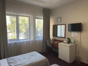a hotel room with a bed and a desk with a computer at Saya Hotel Almaty in Almaty