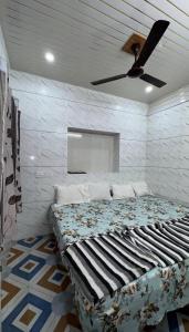 a bedroom with a bed with a ceiling fan at New brahmani Bhavan in Dwarka