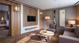 a living room with a couch and a table at Ramada by Wyndham Zhengzhou East in Zhengzhou
