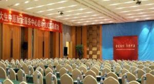 an auditorium with chairs and a screen in a room at Ramada by Wyndham Zhengzhou East in Zhengzhou