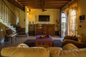 uma sala de estar com um sofá e uma televisão em Il Nido di Giulia em Asciano