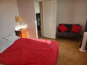 a bedroom with a red bed and a couch at Digital Detox Relaxation and Games in Roquefort-la-Bédoule