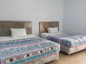 Dos camas una al lado de la otra en una habitación. en Km 31 Sujono Guesthouse, en Bromo