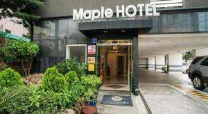 a hotel with a sign on the front of a building at Jeju Maple Hotel in Jeju