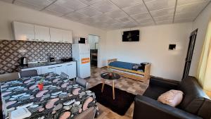 Una cocina y una sala de estar con una mesa y un sofá. en Napoles complejo, en Villa Las Rosas