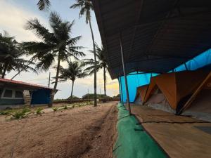 un edificio azul en una playa con palmeras en Zone 51 Malpe - Beach Camping, en Udupi 26 fotos más
