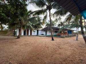 una casa en la playa con palmeras delante en Zone 51 Malpe - Beach Camping, en Udupi