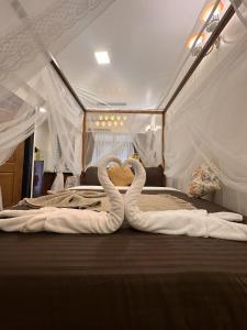 two swans made out of towels on a bed at Sunset holidays in Colva