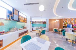 Un restaurante con mesas y sillas y una cocina. en Jinjiang Inn Jinan Shimao Kuanhouli Quancheng Road, en Jinan