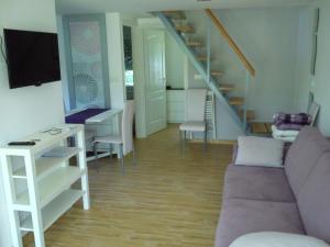 sala de estar con sofá y escalera en Judit Apartman, en Vonyarcvashegy
