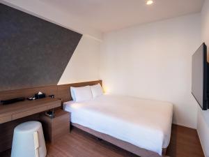 a small bedroom with a bed and a television at Sakura Terrace The Gallery in Kyoto