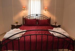 a bedroom with a red bed with red pillows at Vrokastro Apartments in Istro