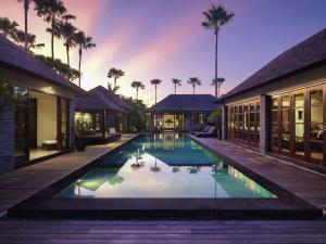 Una vista exterior de una villa con piscina. en Peppers Seminyak, en Seminyak