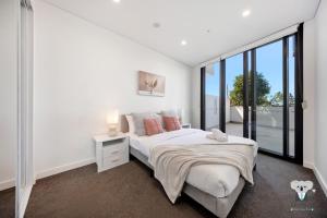 a bedroom with a bed and a large window at KozyGuru | Thornleigh | Nice Cosy Close to All in Thornleigh