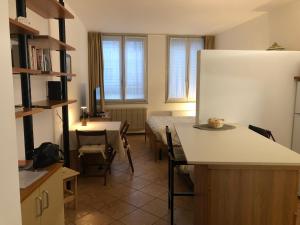 a kitchen with a bed and a table and a refrigerator at Casa Alba Chiara con posto auto in Trieste