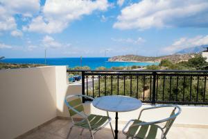 a table and chairs on a balcony with a view of the ocean at Vrokastro Apartments in Istro