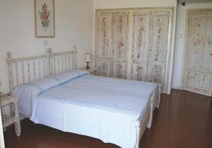 a bedroom with a white bed and two large doors at IHR Hotel San Paolo in Porto San Paolo