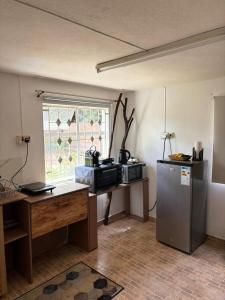 a kitchen with a refrigerator and a table and a window at Chez Hedley Résidence : Couple/Business in Pointe aux Sable