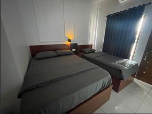 une petite chambre avec deux lits et une fenêtre dans l'établissement SG Hotel Pangandaran, à Pangandaran 4 autres photos