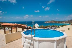 a swimming pool on the roof of a house with the ocean at Vrokastro Apartments in Istro