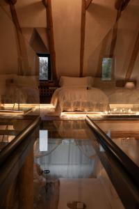 a bedroom with a bed and a reflection in a window at Castelul de Lut - Eco Boutique Guesthouse in Porumbacu de Sus