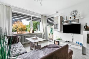 a living room with a couch and a tv at Kleine Auszeit am Meer in Büsum