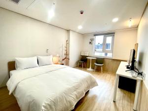 a bedroom with a large white bed and a window at Bonghwang Inn BonghwangMansion2 in Gyeongju