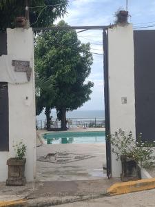 Una puerta abierta con un gato acostado junto a una piscina. en Cocos Camp, en Acapulco