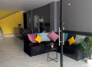 a living room with a couch with colorful pillows at Hotel Mochomos Huajuapan in Huajuapan de León +2 photos