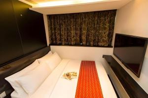 a small room with a bed and a television at Noble Park Hotel in Hong Kong