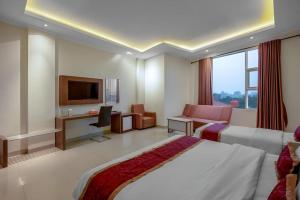 a hotel room with a bed and a television at Raffleshom Hotel in Bandung