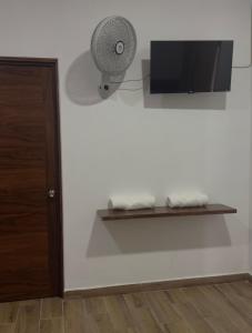 a room with a tv and a fan on a wall at Hotel Mochomos Huajuapan in Huajuapan de León