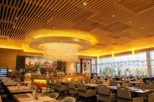 泉州市にあるQuanzhou Guest House Hotelのテーブルと椅子とシャンデリアのあるダイニングルーム