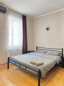 a bedroom with a large bed in front of a window at GNT+ in Tbilisi City