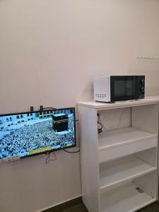 a computer monitor and a microwave on a shelf at Sand Adventures Oasis in Bidiyah +7 photos