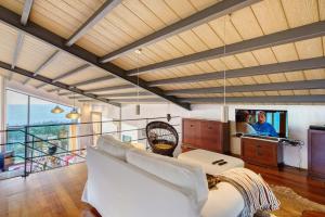 a living room with a white couch and a tv at Serreta Island Home in Serreta