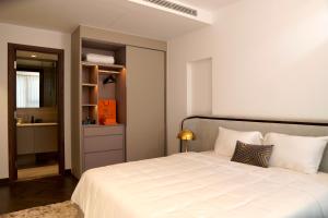 a bedroom with a large white bed and a bathroom at Lancaster Legacy Hotel & Apartments in Ho Chi Minh City +31 photos