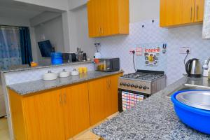 a kitchen with wooden cabinets and a stove top oven at gilgalhomes in Gatunga