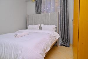a bedroom with a bed with white sheets and pillows at gilgalhomes in Gatunga