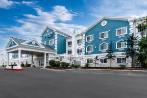 a large blue and white hotel with a parking lot at Clarion Suites Anchorage Downtown in Anchorage