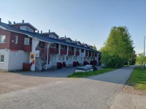 a row of buildings with a bench next to a road at Levistar studio with sauna in Levi