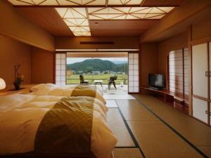 a bedroom with a large bed and a television at Shiratamano Yu Kahou in Shibata