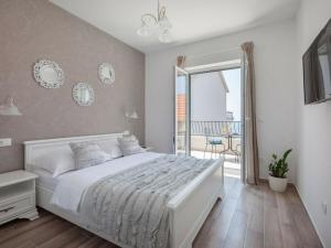 a bedroom with a white bed and a balcony at Rustic Villa Nina Tucepi in Tučepi +56 photos