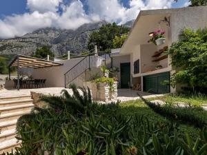 a house with mountains in the background at Rustic Villa Nina Tucepi in Tučepi
