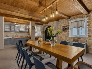 a kitchen and dining room with a wooden table and chairs at Rustic Villa Nina Tucepi in Tučepi
