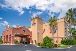 a hotel with palm trees in front of a building at Comfort Suites Lady Lake - The Villages in The Villages