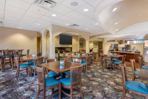 a dining room with wooden tables and chairs at Comfort Suites Lady Lake - The Villages in The Villages